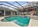 Inviting pool area with a waterfall feature and screened enclosure at 4825 Scott Rd, Lutz, FL 33558