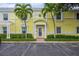 Exterior view of yellow building with palm trees and parking at 5005 Coquina Key Se Dr # E, St Petersburg, FL 33705