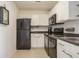 Kitchen with white cabinets, black appliances, and granite counters at 5005 Coquina Key Se Dr # E, St Petersburg, FL 33705