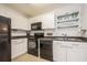 Modern kitchen with black appliances and white cabinets at 5005 Coquina Key Se Dr # E, St Petersburg, FL 33705
