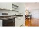 Kitchen with white cabinets, black appliances, and view of dining area at 5005 Coquina Key Se Dr # E, St Petersburg, FL 33705
