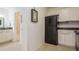 Kitchen with white cabinets, black appliances, and view of bathroom at 5005 Coquina Key Se Dr # E, St Petersburg, FL 33705