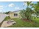 Large backyard with grassy area, fire pit, and mature cactus at 7698 Cardiff Ct, St Petersburg, FL 33709