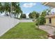 Large grassy backyard with a patio and white fence at 7698 Cardiff Ct, St Petersburg, FL 33709