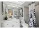 Bathroom boasts a white vanity, toilet and shower with patterned curtain at 7698 Cardiff Ct, St Petersburg, FL 33709
