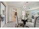 Dining area with glass table, four chairs, view into kitchen and living room at 7698 Cardiff Ct, St Petersburg, FL 33709