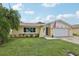 Cute ranch home with a landscaped lawn and attached garage at 7698 Cardiff Ct, St Petersburg, FL 33709