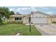 Updated ranch home with a white garage door and American flag at 7698 Cardiff Ct, St Petersburg, FL 33709