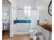 Modern bathroom featuring tiled shower with blue accents, floating wood vanity, and access to the adjacent bedroom at 7701 40Th N Ter, St Petersburg, FL 33709