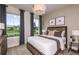 Cozy bedroom with a wooden bed frame, neutral bedding, and two windows at 9409 Barnacle Ln, Parrish, FL 34219