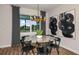 Elegant dining room with marble table, black chairs, and large abstract art at 9409 Barnacle Ln, Parrish, FL 34219