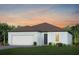One-story home with light blue exterior, brown roof, and two-car garage at 9409 Barnacle Ln, Parrish, FL 34219