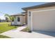 Tan house exterior with a two-car garage and walkway leading to the front entrance at 112 Sidney Ct, Rotonda West, FL 33947