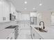 Modern kitchen featuring white cabinets, stainless steel appliances, and a large island at 112 Sidney Ct, Rotonda West, FL 33947