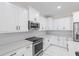 Modern kitchen with white cabinets, stainless steel appliances, and quartz countertops at 112 Sidney Ct, Rotonda West, FL 33947