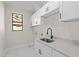 Well-appointed laundry room with white cabinets and quartz countertops at 112 Sidney Ct, Rotonda West, FL 33947
