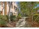 Walkway leading to a townhome entrance with mature trees and landscaping at 11522 Fountainhead Dr, Tampa, FL 33626