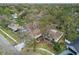 Aerial view showcasing a house with a pool in a wooded neighborhood at 11905 Trevino Pl, Tampa, FL 33624