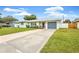 House exterior with gray garage door and landscaping at 1429 Pinebrook Dr, Clearwater, FL 33755