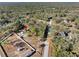 Aerial view of a house on a large lot with surrounding trees and other homes at 14450 Lancer Rd, Spring Hill, FL 34610