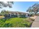 Tan house with lush green lawn, palm trees, and driveway at 1526 Leland Dr # 1525, Sun City Center, FL 33573