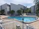 Community pool with surrounding lounge chairs and patio at 169 Medallion Blvd # E, Madeira Beach, FL 33708