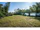 Large backyard with grassy area and storage sheds at 1820 Sutherland W Dr, Palm Harbor, FL 34683