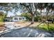 White house with blue trim, large yard at 1820 Sutherland W Dr, Palm Harbor, FL 34683