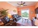 Bright living room with hardwood floors, a ceiling fan, and access to a balcony at 21012 Picasso Ct # J205, Land O Lakes, FL 34637