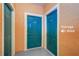 Building entrance with teal doors and storage area at 2749 Via Cipriani # 1010B, Clearwater, FL 33764