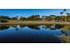 Serene golf course pond reflecting lush trees and sky at 3541 Oak Lake Dr, Palm Harbor, FL 34684