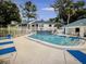 Community pool with lounge chairs and surrounding trees at 3558 Indigo Pond Dr # 10, Palm Harbor, FL 34684