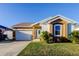 Tan house with white garage door, palm trees, and a manicured lawn at 531 Canal Way, Oldsmar, FL 34677