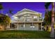 Two-story house with a large deck, palm trees, and a well-manicured lawn at 555 Gulf Dr, Crystal Beach, FL 34681