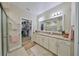 Elegant bathroom with granite countertops, walk-in shower, and large mirror at 676 Allegheny Dr, Sun City Center, FL 33573