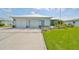 Light green house exterior with two-car garage and landscaping at 676 Allegheny Dr, Sun City Center, FL 33573