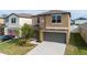 Two-story house with gray garage door and landscaping at 7153 Samuel Ivy Dr, Tampa, FL 33619