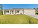 One-story home with light beige exterior, dark gray roof, and a two-car garage at 7258 Bridgeport Ln, Englewood, FL 34224