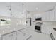 Modern kitchen featuring white cabinets, stainless steel appliances and an island at 7258 Bridgeport Ln, Englewood, FL 34224