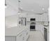 Modern kitchen with white cabinets, stainless steel appliances, and quartz countertops at 7258 Bridgeport Ln, Englewood, FL 34224