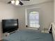 Bedroom with large TV, window seat, and a queen bed at 8408 Canterbury Lake Blvd, Tampa, FL 33619