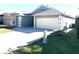 Front view of a light green house with a two-car garage and a paved driveway at 8408 Canterbury Lake Blvd, Tampa, FL 33619
