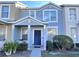 Two-story townhome with blue and beige exterior, landscaping, and a walkway at 9822 Carlsdale Dr, Riverview, FL 33578