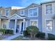 Two-story townhome with blue and beige exterior, landscaping, and a walkway at 9822 Carlsdale Dr, Riverview, FL 33578