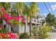 Two-story house with two-car garage, lush landscaping, and tropical plants at 12116 Lagoon Ln, Treasure Island, FL 33706