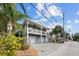 Two-story house with two-car garage, elevated porch, and tropical landscaping at 12116 Lagoon Ln, Treasure Island, FL 33706