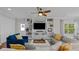 Living room with hardwood floors, built-in shelving, and a large TV at 12116 Lagoon Ln, Treasure Island, FL 33706