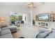 Spacious living room with sectional sofa, large TV, and access to pool area at 12739 Rainwashed Loop, Parrish, FL 34219