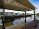 Wooden covered dock with boat lift overlooking canal at 170 S Saint Thomas Cir, Apollo Beach, FL 33572