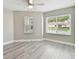 Bright bedroom featuring neutral walls, vinyl plank flooring and large windows at 1709 Edgewater Ln, Palmetto, FL 34221